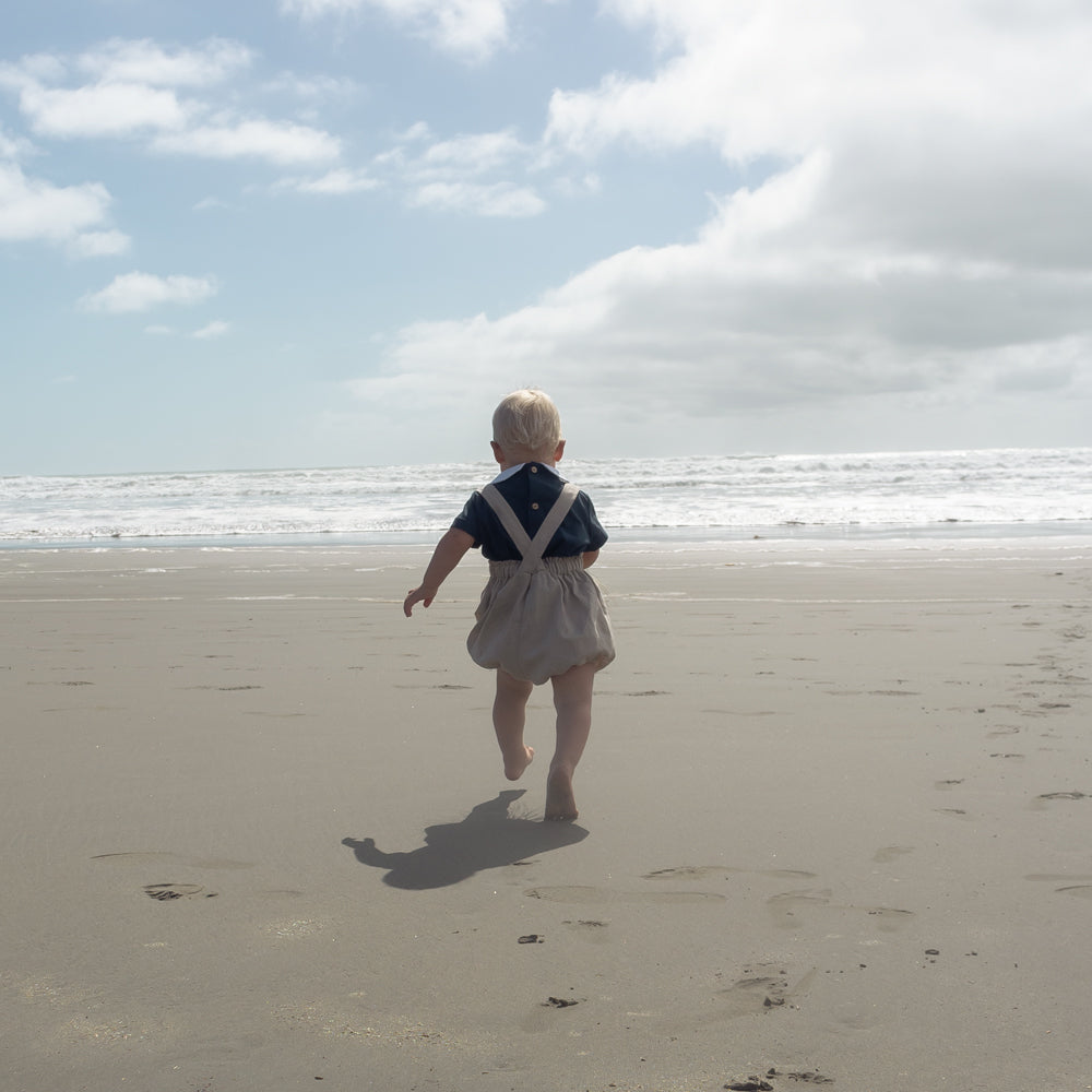 Young boy wearing Little Noah, organic cotton navy shirt with white Peter Pan collar — by Twee & Co 