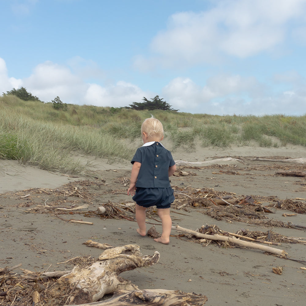 Young boy wearing Little Noah, organic cotton navy shirt with white Peter Pan collar — by Twee & Co 