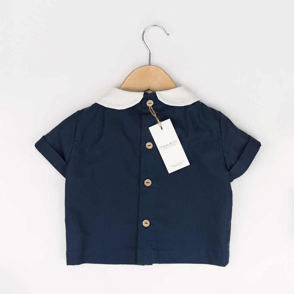 Young boy wearing Little Noah, organic cotton navy shirt with white Peter Pan collar — by Twee & Co
