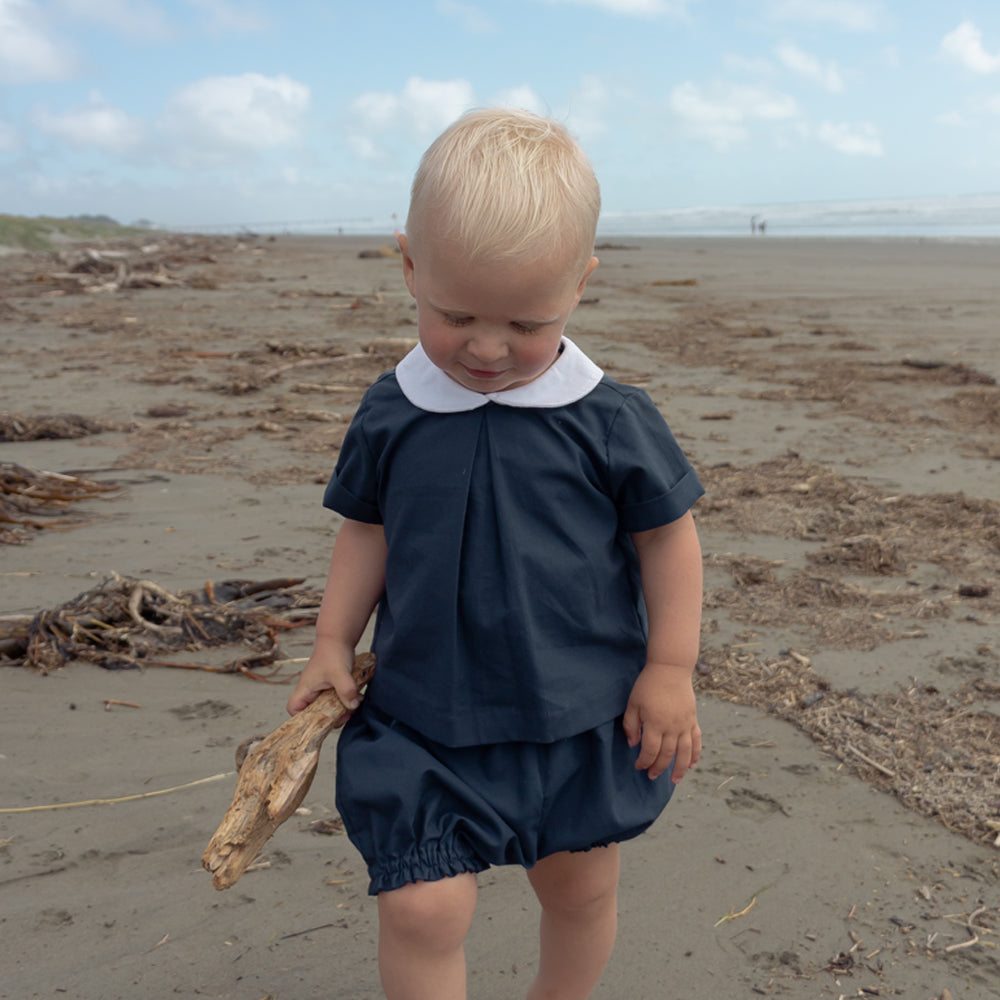 Toddler wearing Little Noah, organic cotton navy shirt with white Peter Pan collar — by Twee & Co