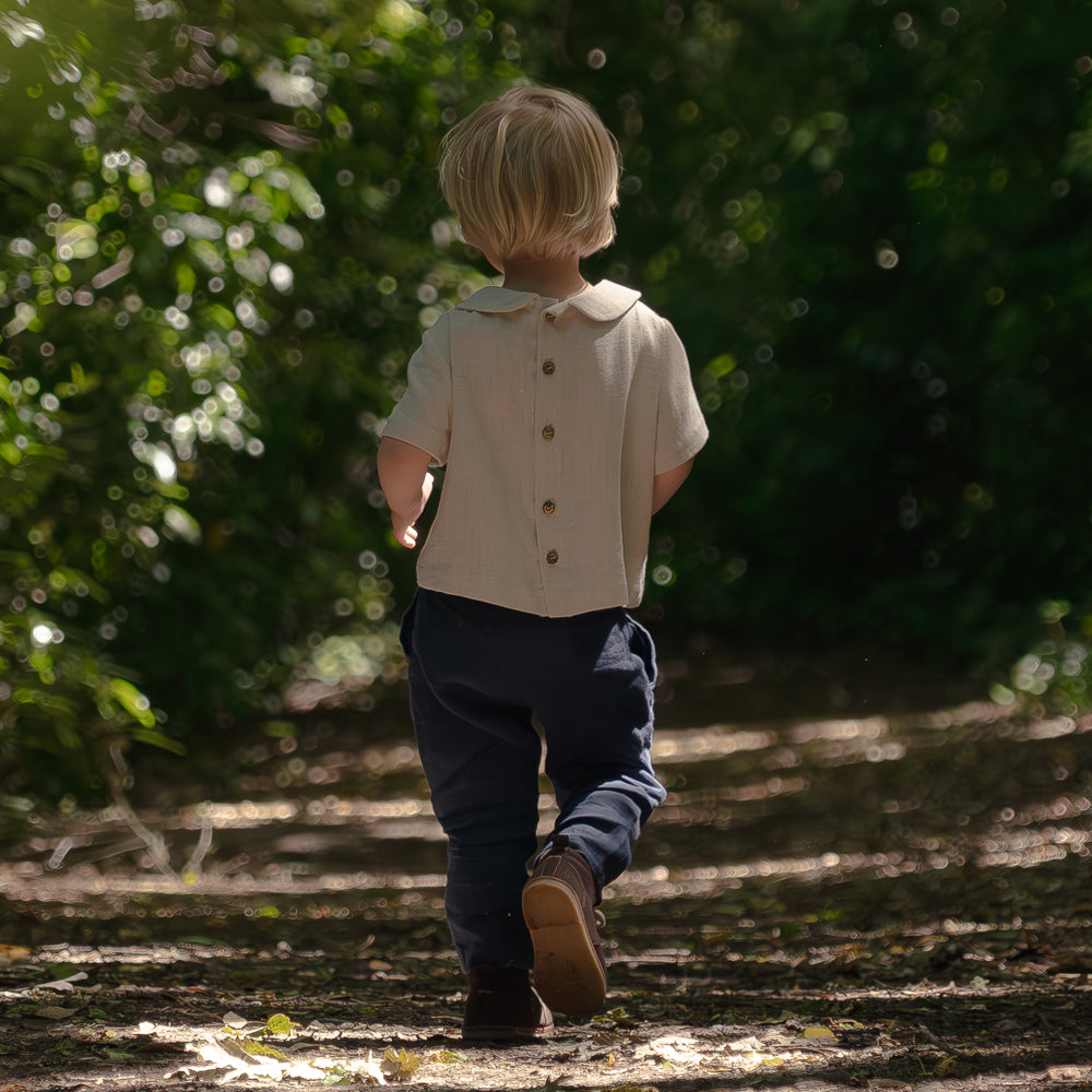 Boy walking in nature wearing Darcy Linen Shirt by Twee & Co