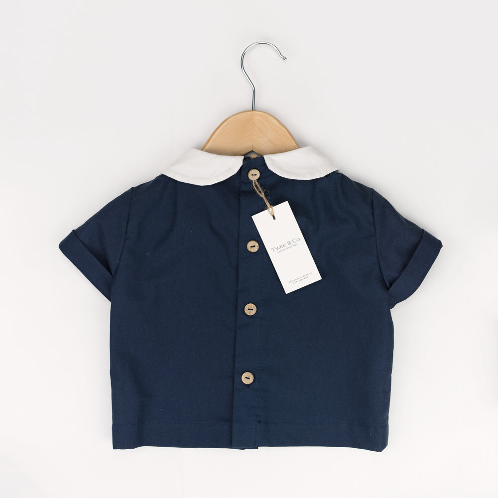 Young boy wearing Little Noah, organic cotton navy shirt with white Peter Pan collar — by Twee & Co 