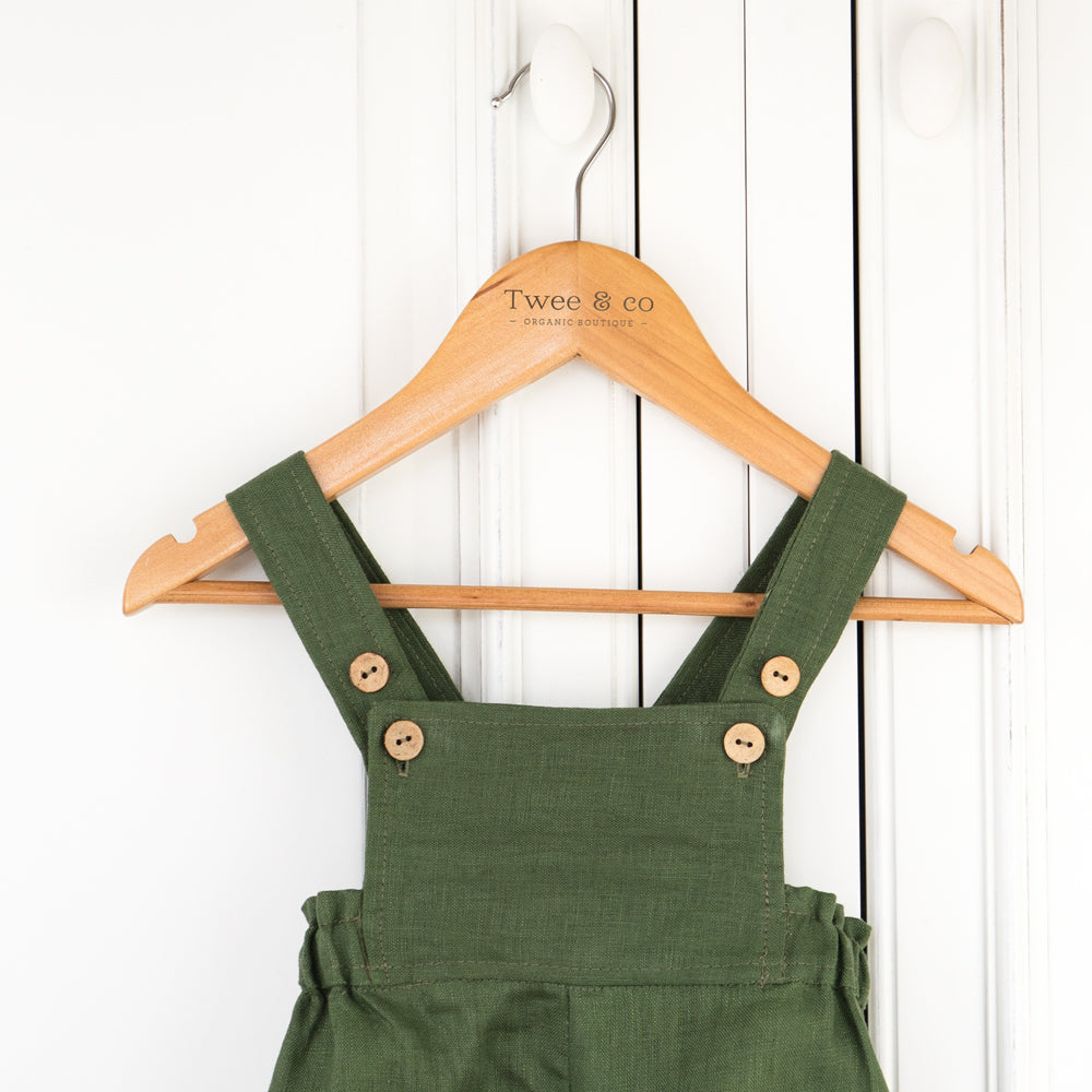 Toddler wearing organic linen romper in forest green by Twee & Co